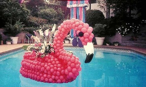 Pink flamingo balloon sculpture floating in a pool.